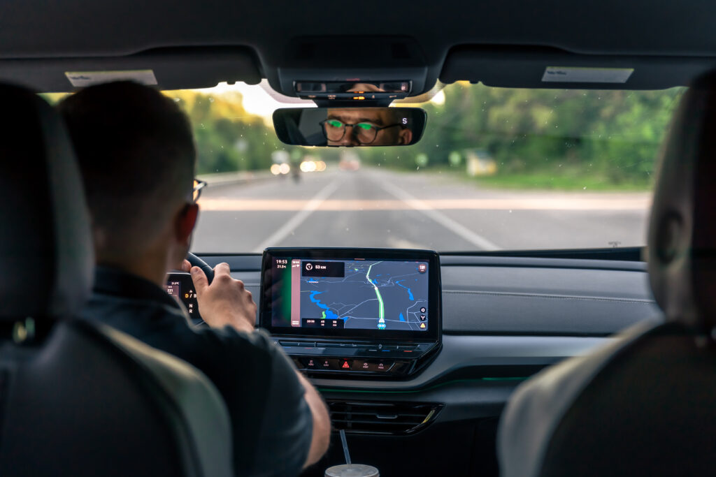 A male driver drives at speed through the streets of the city, a view from inside the car.