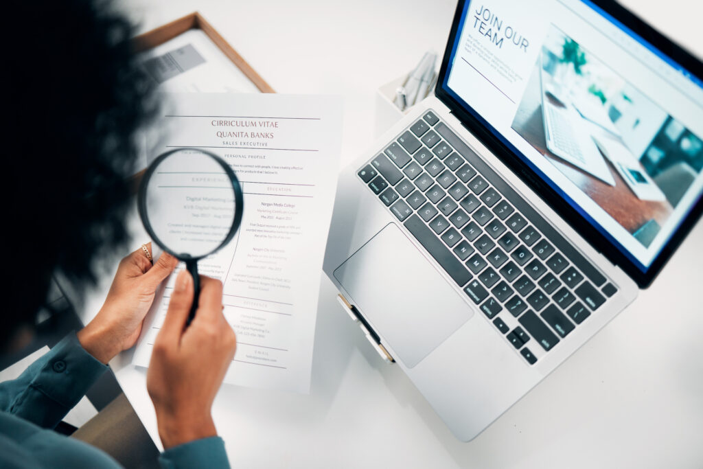 Magnifying glass, computer and woman reading document in the office for company recruitment website.